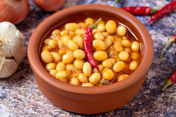 Hot turkish bean stew on wooden background. Ispir beans cooked in a casserole - Kuru Fasulye