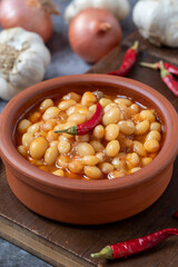 Hot turkish bean stew on wooden background. Ispir beans cooked in a casserole - Kuru Fasulye. Top view