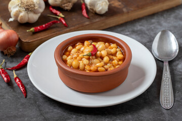 Hot turkish bean stew on dark background. Ispir beans cooked in a casserole - Kuru Fasulye