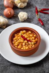 Hot turkish bean stew on dark background. Ispir beans cooked in a casserole - Kuru Fasulye
