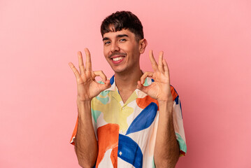 Young mixed race man isolated on pink background cheerful and confident showing ok gesture.