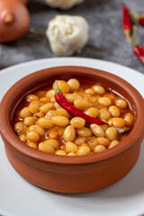 Hot turkish bean stew on dark background. Ispir beans cooked in a casserole - Kuru Fasulye