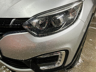 Silver-colored car wash at a self-service car wash. Washing the car with foam