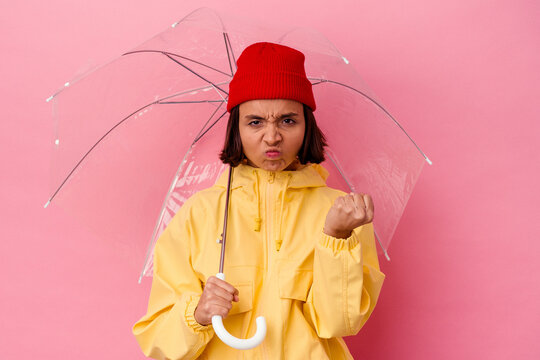 Young woman holds umbrella, worried about potential rain.