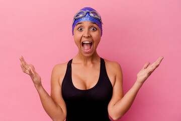 Young swimmer mixed race woman isolated on pink background receiving a pleasant surprise, excited...