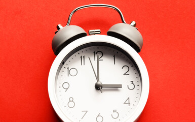 White alarm clock on red background