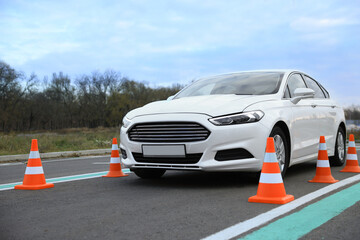 Modern car on test track with traffic cones. Driving school