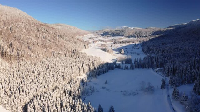 Survol drone de la vall&eacute;e de la Valserine, Jura, Mijoux. Paysage d&rsquo;hiver recouvert de neige, ciel bleu et beau temps.