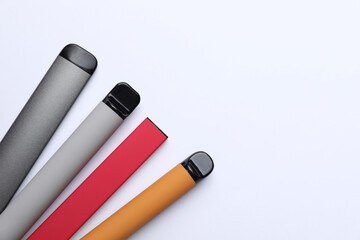 Different electronic cigarettes on white background, top view