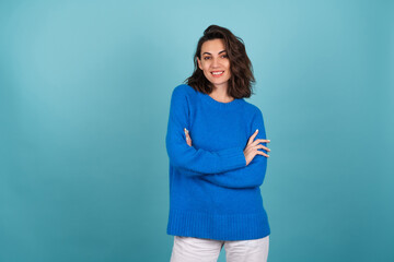 Woman in a blue knitted sweater and natural make-up, curly short hair, with an infectious radiant...