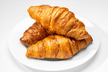 Fresh and tasty French croissant. Croissant on white plate and white background.