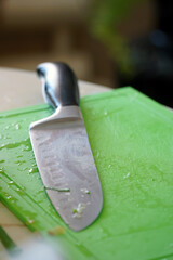 Kitchen knife on a green plastic cutting board