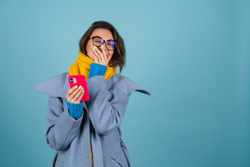 Spring autumn portrait of a woman in a blue knitted sweater, glasses, a yellow bright scarf and a...