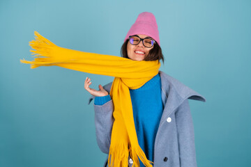 Spring autumn portrait of a woman in a blue knitted sweater, glasses, a yellow bright scarf and a...