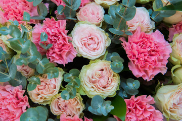 Roses in white vases indoors. Bouquets of roses in the enlarged window.