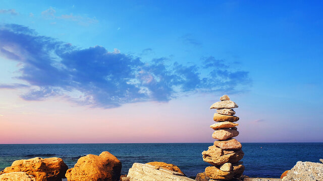 Pyramid of stones on the beach. The concept of harmony and relaxing .