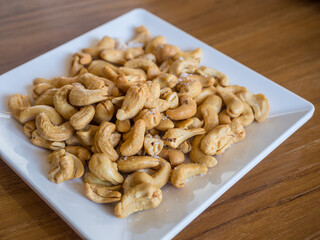 cashew on a square white dish 
