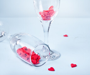 Two champagne glasses with red heart shaped candy. Valentine's Day concept.