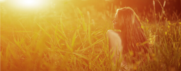 Young hipster model woman Casual Girl in field in Sunset in spring, summer landscape background...
