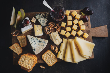 Different arts of cheese with grape on wooden