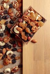 Mix of nuts and raisins on a wooden table.
