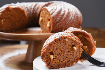 Close up of sliced Panettone cake or Bundt cake decorated icing sugar on the plate and stand. Shallow depth of field