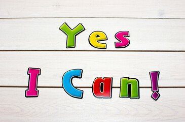 Yes I Can! Positive affirmation, statement. Bold neon letters on white washed wood table.
