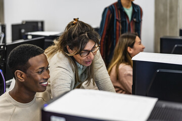Young Afro student with teacher during university lesson in classroom - Education and technology concept