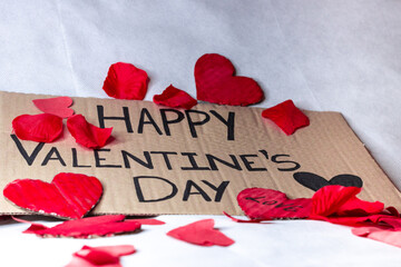 happy valentine's day poster with red petals and hearts on a white background