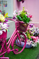 Fototapeta na wymiar Decorative plants and plastic flowers in front of the shop. Purple plastic garden decoration.
