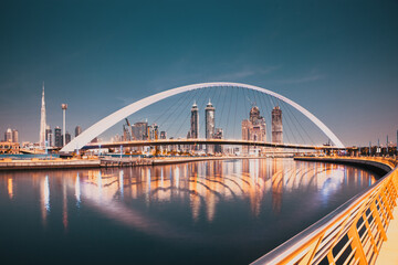 DUBAI, UAE - FEBRUARY 2018: Colorful sunset over Dubai Downtown skyscrapers and the newly built Tolerance bridge as viewed from the Dubai water canal.