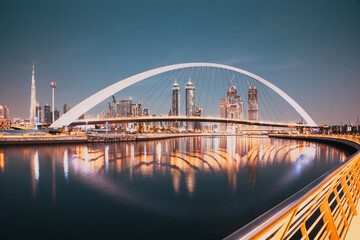 DUBAI, UAE - FEBRUARY 2018: Colorful sunset over Dubai Downtown skyscrapers and the newly built Tolerance bridge as viewed from the Dubai water canal.