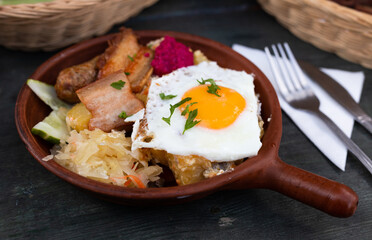 Scrambled eggs with fried bacon and potatoes served on plate