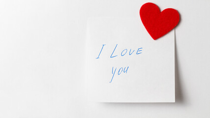 A close up of a white sticky note with the word I Love You with red heart. Valentine's Day. Valentine's Day background. I love you lettering text. love concept.
