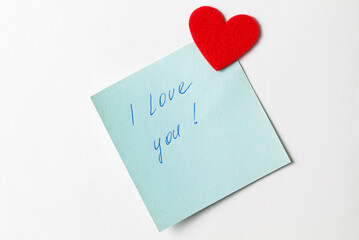 A close up of a blue sticky note with the word I Love You with red heart. Valentine's Day. Valentine's Day background. I love you lettering text. love concept.