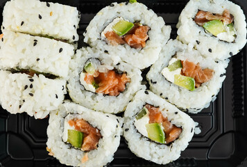 Una bandeja con piezas variadas de sushi. Rollo California.
