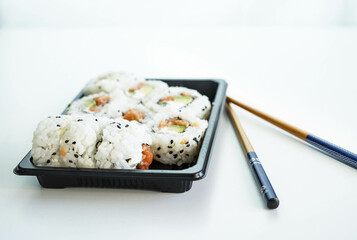 Una bandeja con piezas variadas de sushi. Rollo California.
