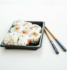 Una bandeja con piezas variadas de sushi. Rollo California.
