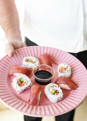 Un plato con piezas variadas de sushi.
