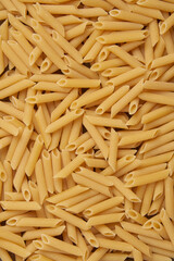 pasta concept hundreds of hollow cylinder-shaped penne pasta with slanted edges being lay in full area
