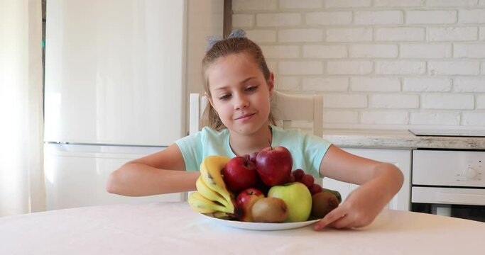 the child eats fruits with pleasure. The girl eats healthy food. the concept of children's health