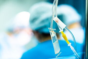 Transparent tubes of a medical dropper with saline on a blurred background. Selective focus.