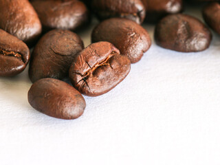 Close up of roasted coffee beans on white background