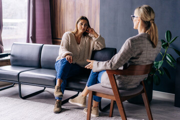 A young woman in a consultation with a professional psychologist listens to advice on improving behavior in life. The modern millennial woman is developing mindfulness and psychological health. - obrazy, fototapety, plakaty