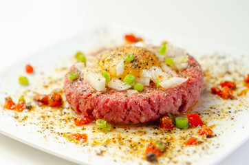 Beef steak tartare with raw egg yolk and onion with tomato - 480962943