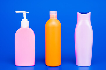 Multicolor plastic containers for liquid toiletries and cosmetic products in row, bottles