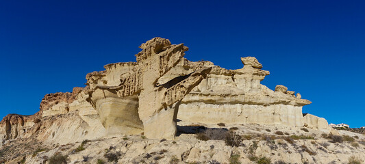 view of the famous sandstone erosions and hoodoos in Bolnuevo under a clear blue sky