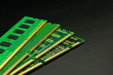 Computer Random Access Memory (RAM) chips on black wooden floor.                     