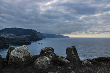 Grandes monta&ntilde;as de rocas en las costas del mar con un cielo azul y nubes blancas 