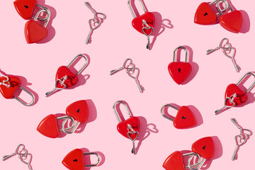 Valentines day creative pattern with heart shaped bright red padlocks and keys on pastel pink...